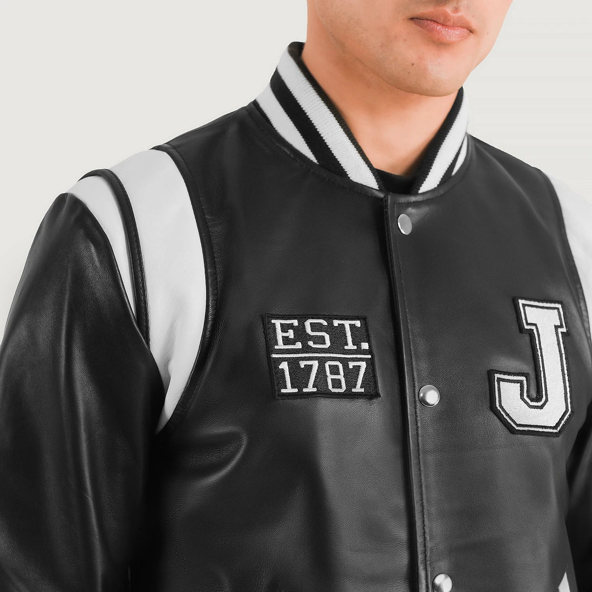 Close-Up Detail of Varsity &amp; Snap Button Hardware on Liberte New Jersey أسود Leather Varsity جاكيت جلد رجالي